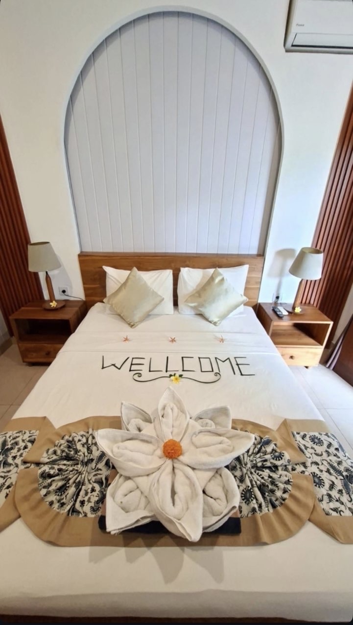 Bedroom prepared with a floral towel welcome